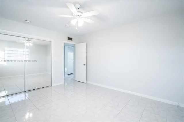 an empty room with a ceiling fan and shower