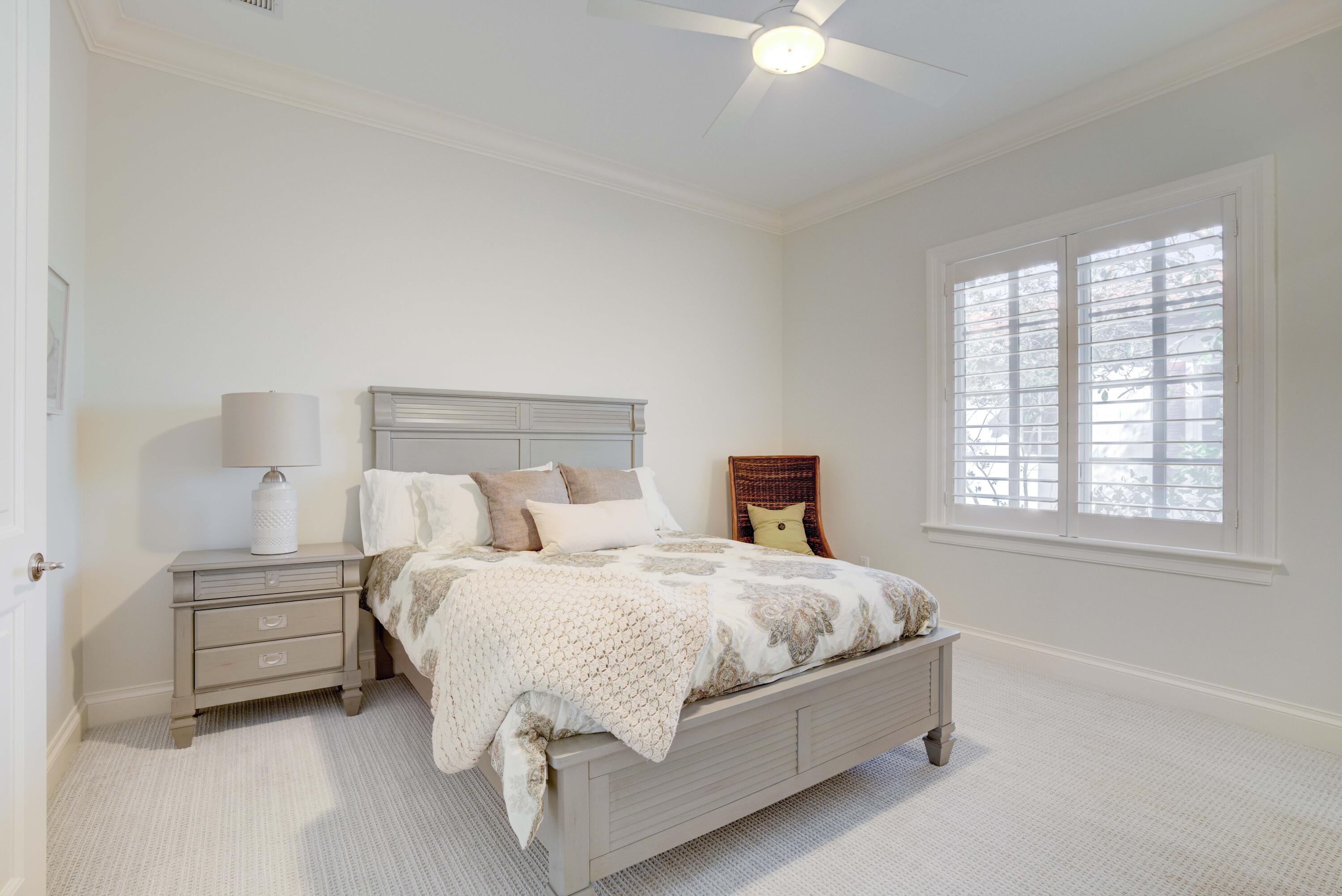 444 Red Hawk Drive Jupiter, FL 33477 - Photo 28 of 58 a bedroom with a bed and a chandelier