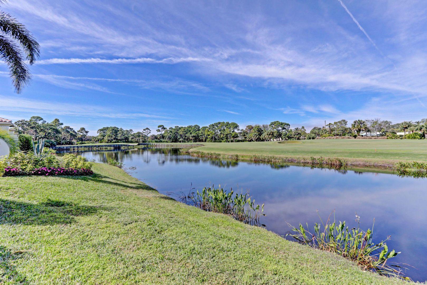 444 Red Hawk Drive Jupiter, FL 33477 - Photo 53 of 58 a view of a lake with houses in the back