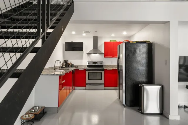a kitchen with stainless steel appliances granite countertop a refrigerator and a stove