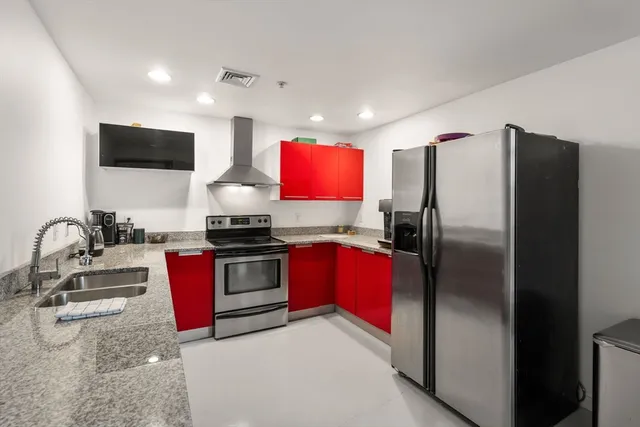 a kitchen with stainless steel appliances granite countertop a refrigerator and a stove