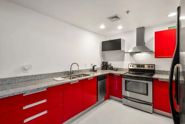 a kitchen with stainless steel appliances granite countertop a stove a sink and a microwave