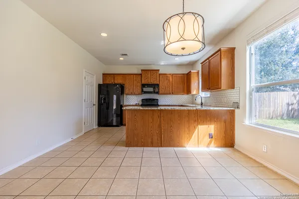 a large kitchen with stainless steel appliances granite countertop a stove and a refrigerator