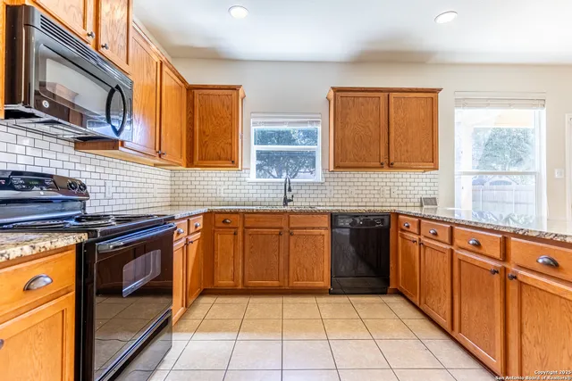 a kitchen with stainless steel appliances granite countertop a stove a sink and a microwave