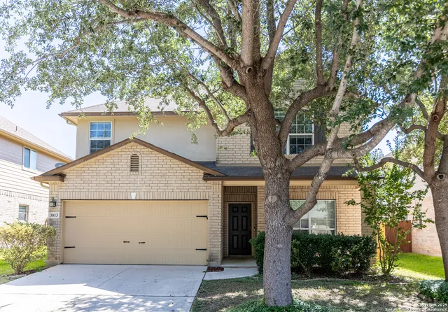 a view of a house with a tree in front