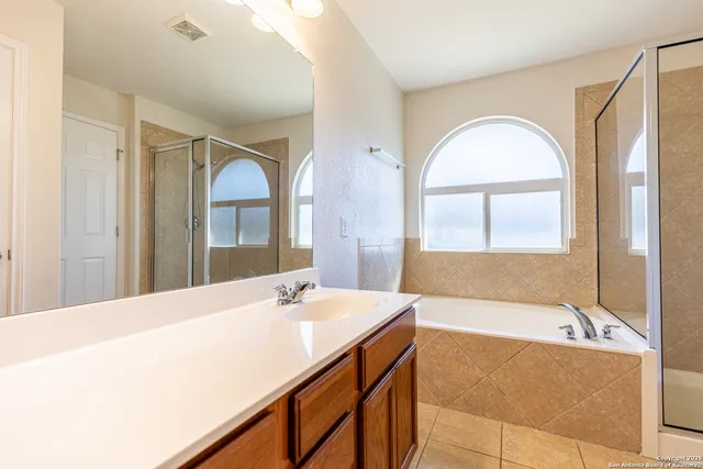 a bathroom with a tub sink and mirror