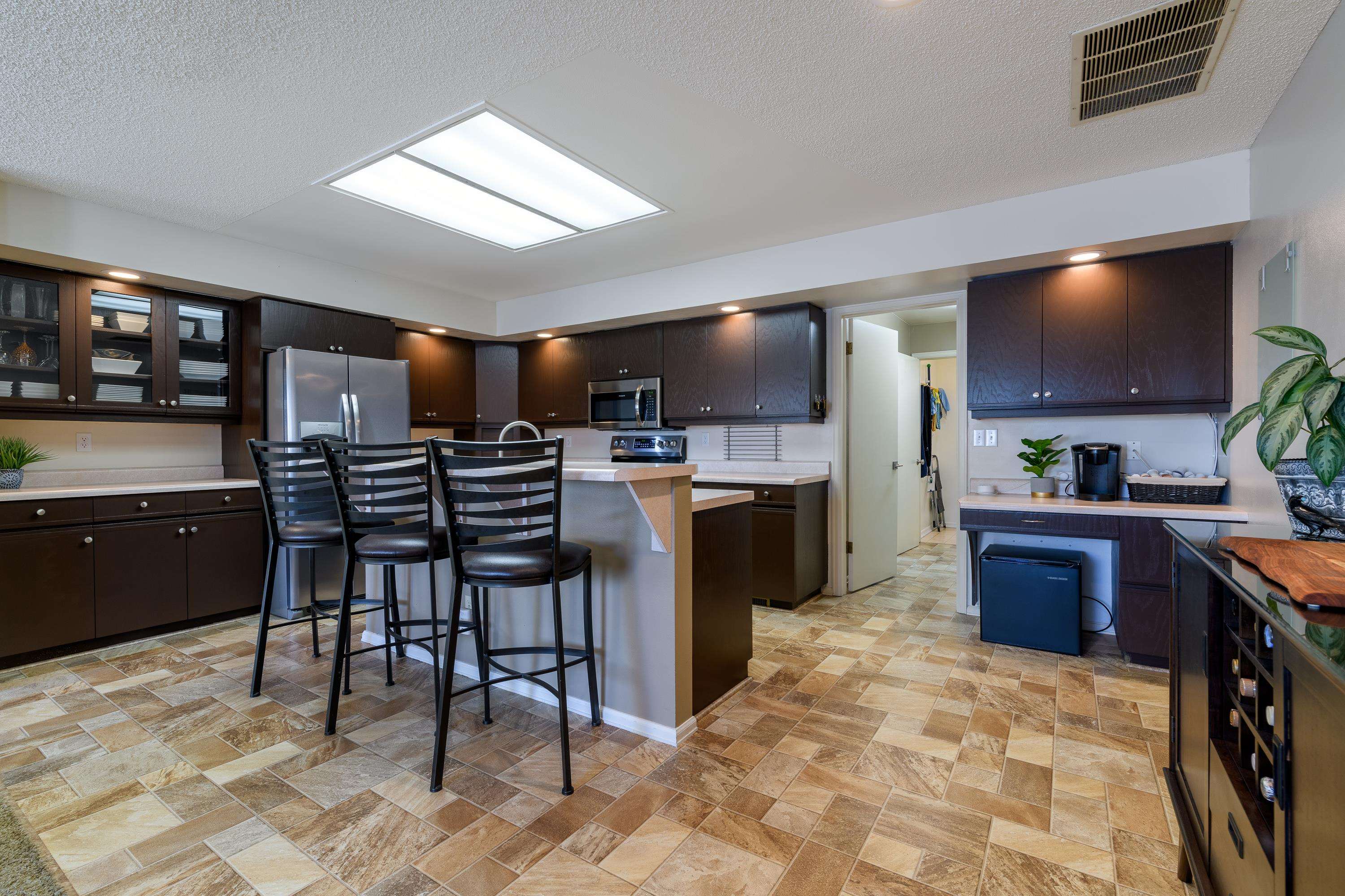 2700 G Road, Unit 5C Grand Junction, CO 81506 - Photo 8 of 25 a kitchen with stainless steel appliances kitchen island granite countertop a table chairs sink and cabinets
