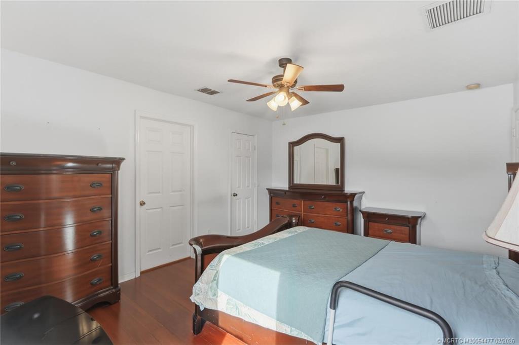 726 Southwest Bond Road Port St. Lucie, FL 34953 - Photo 20 of 31 a bedroom with a large bed and a chandelier