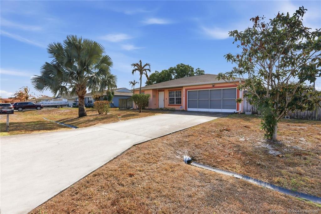 726 Southwest Bond Road Port St. Lucie, FL 34953 - Photo 2 of 31 a view of a house with a yard and wooden fence