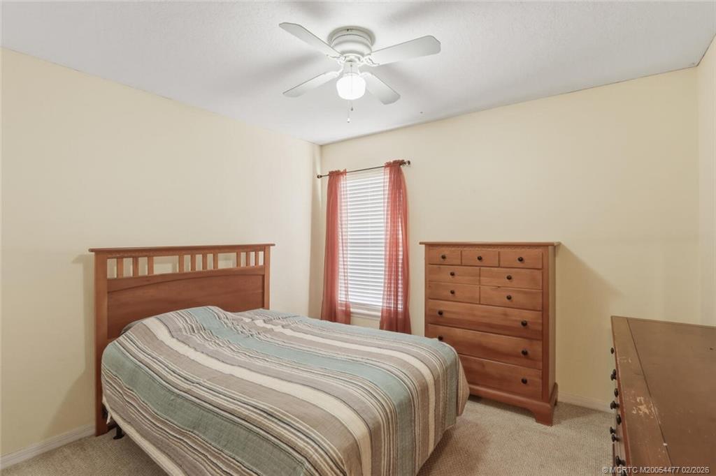 726 Southwest Bond Road Port St. Lucie, FL 34953 - Photo 22 of 31 a bedroom with a bed and a chandelier