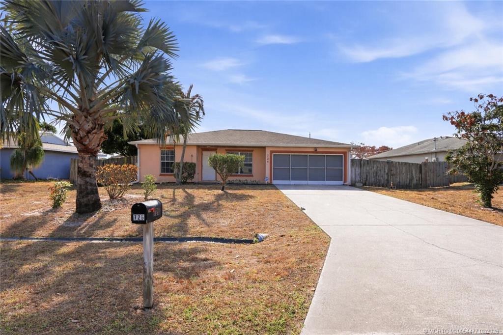 726 Southwest Bond Road Port St. Lucie, FL 34953 - Photo 3 of 31 a front view of a house with a yard and garage
