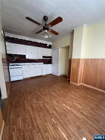 a view of a kitchen with wooden floor and a ceiling fan