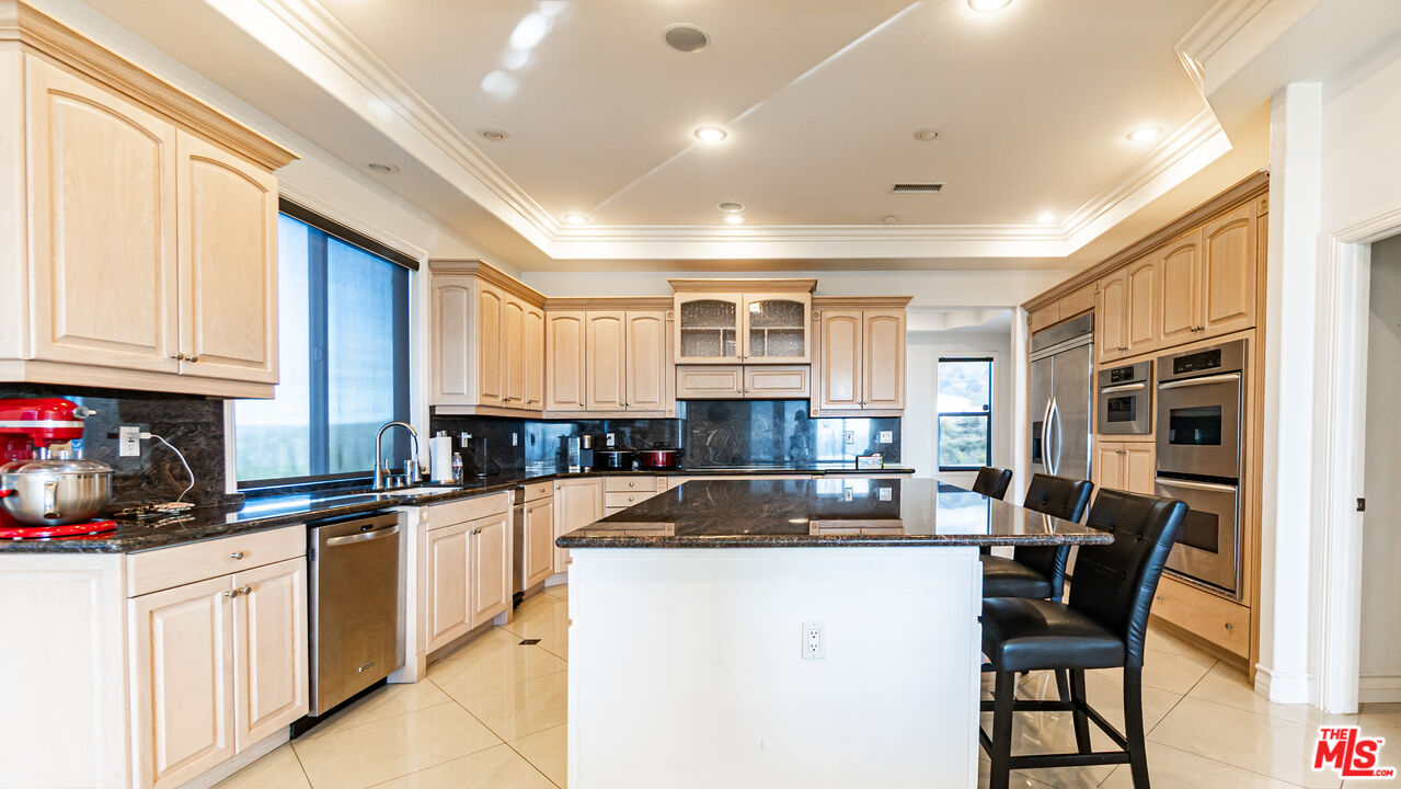 8321 Overview Court Yucaipa, CA 92399 - Photo 19 of 75 a kitchen with kitchen island granite countertop a stove and cabinets