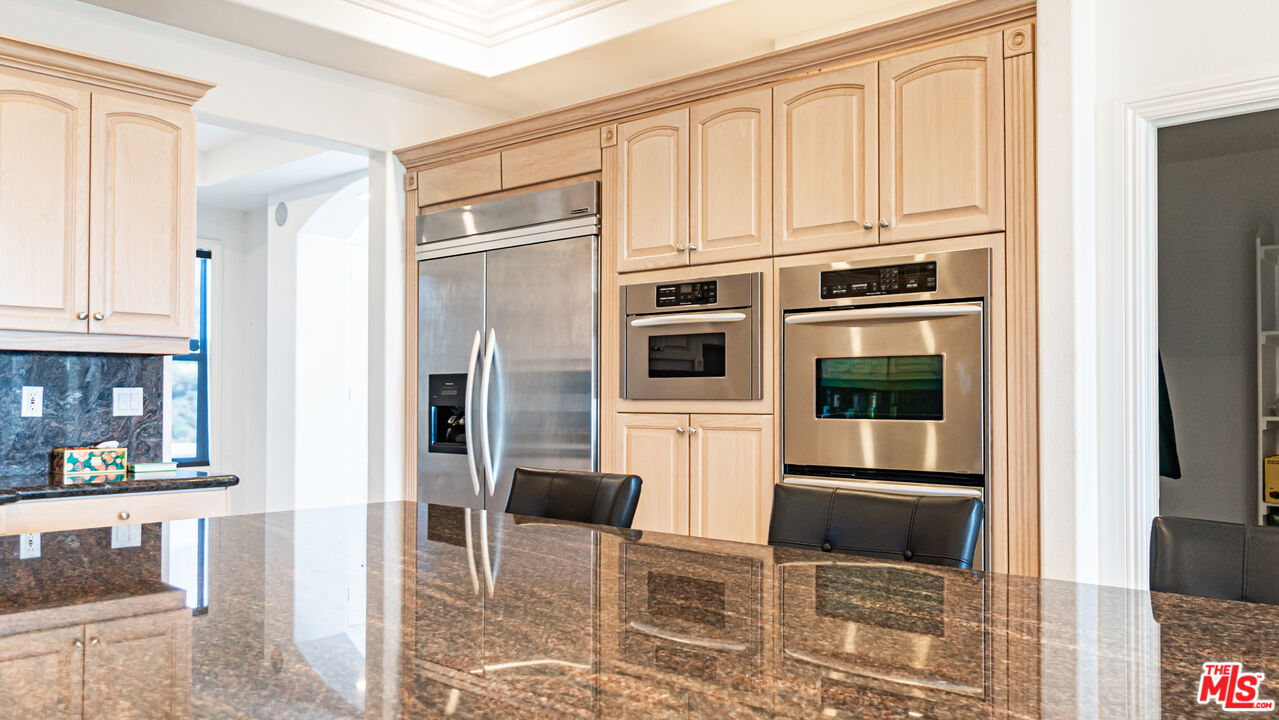 8321 Overview Court Yucaipa, CA 92399 - Photo 21 of 75 a kitchen with stainless steel appliances kitchen island granite countertop a refrigerator and cabinets