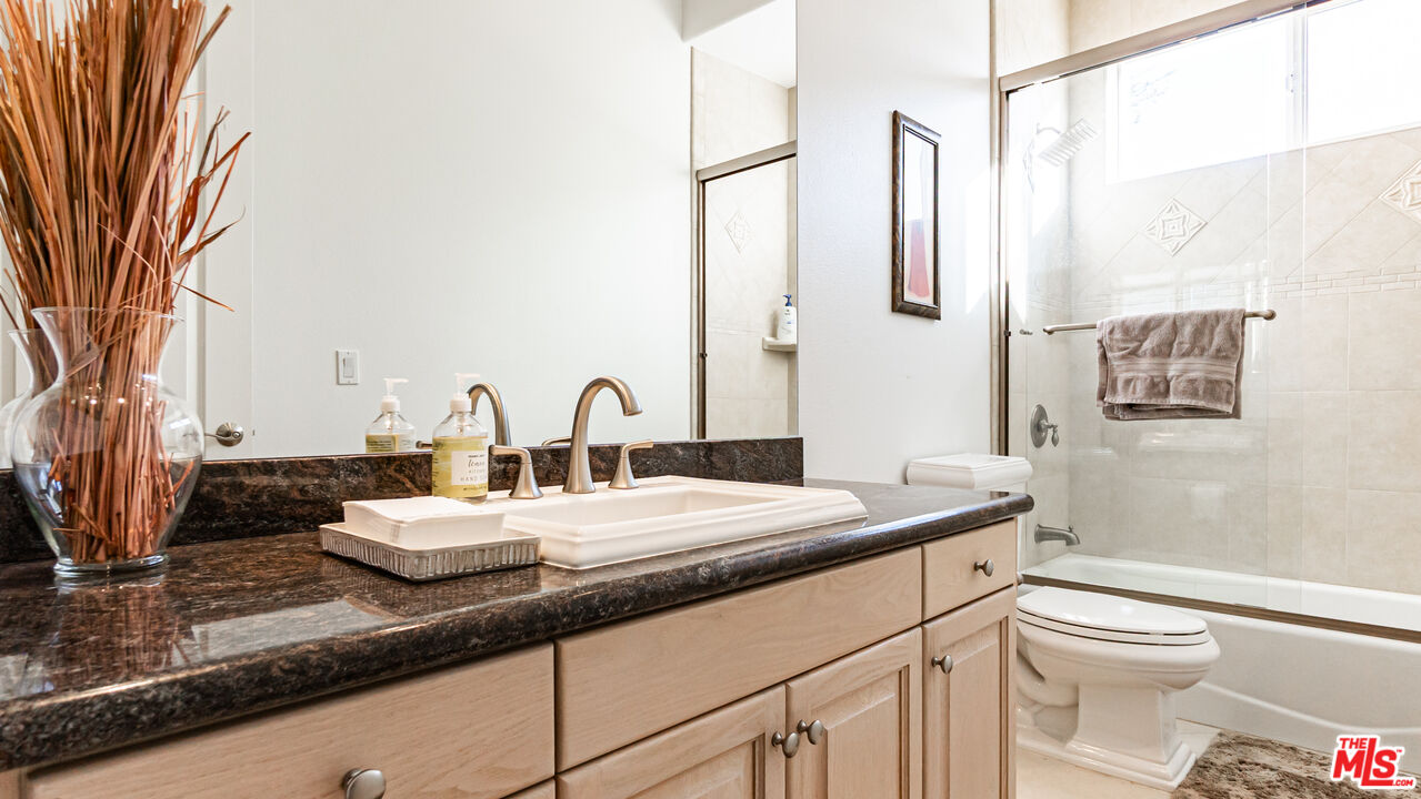 8321 Overview Court Yucaipa, CA 92399 - Photo 27 of 75 a bathroom with a granite countertop sink mirror vanity and toilet
