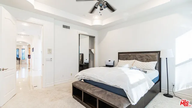 a spacious bedroom with a bed couch and large window