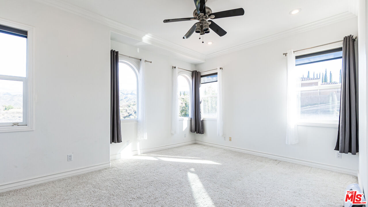 8321 Overview Court Yucaipa, CA 92399 - Photo 52 of 75 an empty room with windows and fan
