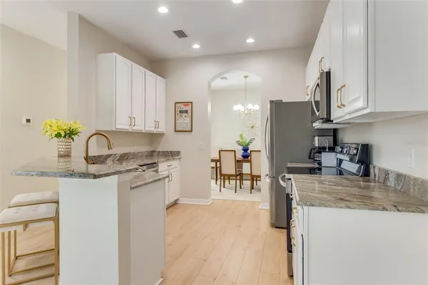 a kitchen with granite countertop a sink stainless steel appliances and cabinets