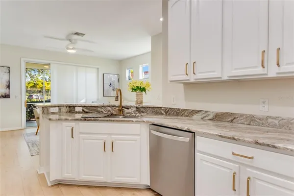 a kitchen with granite countertop white cabinets and a sink