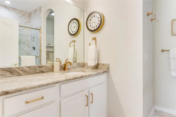 a bathroom with a granite countertop sink and a mirror