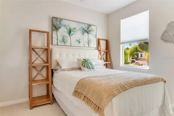 a large bed sitting in a bedroom next to a window