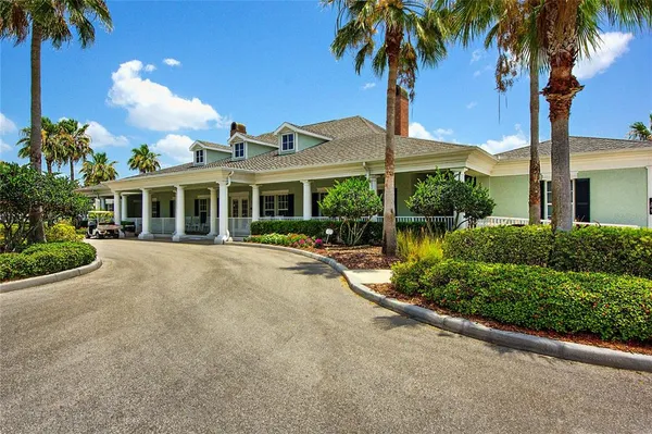front view of a house with a garden and palm trees