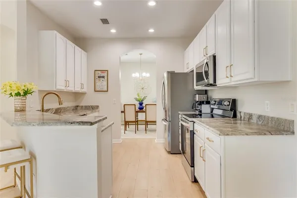 a kitchen with stainless steel appliances granite countertop a sink stove and cabinets