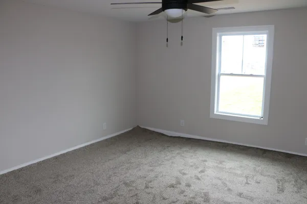 a view of an empty room and a ceiling fan