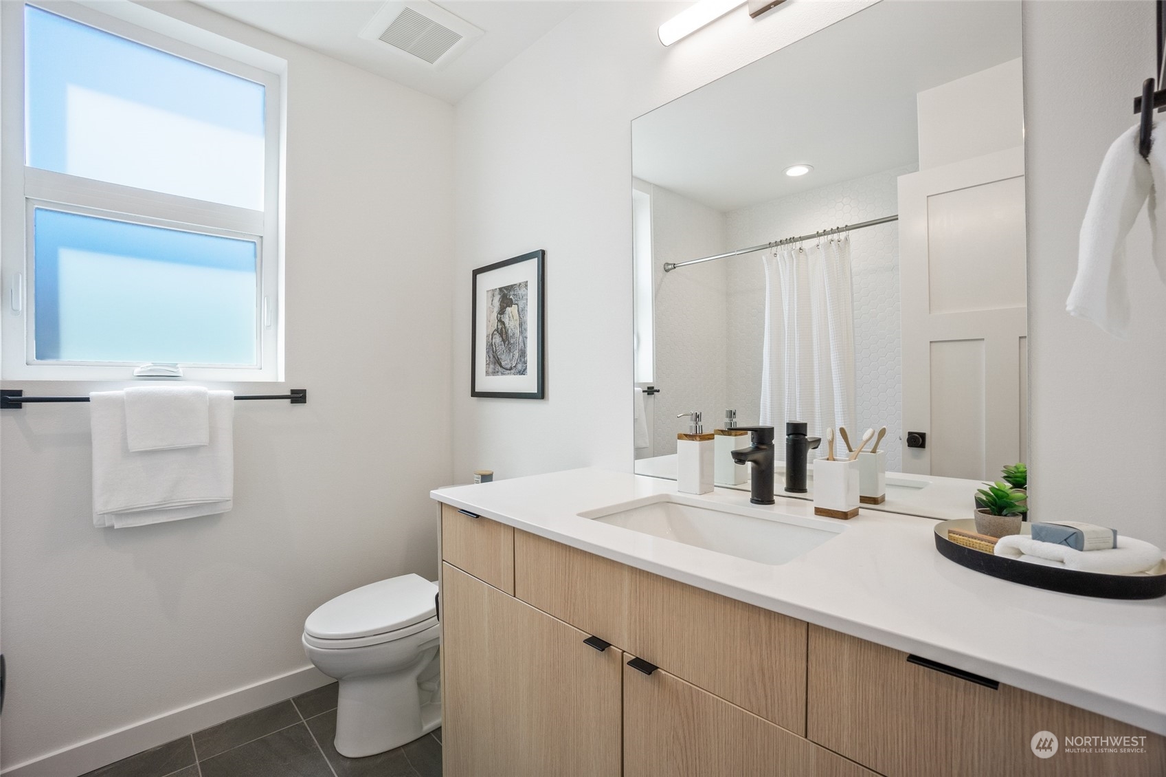 2620 Northwest 62nd Street, Unit B Seattle, WA 98107 - Photo 5 of 34 a bathroom with a sink a toilet and mirror