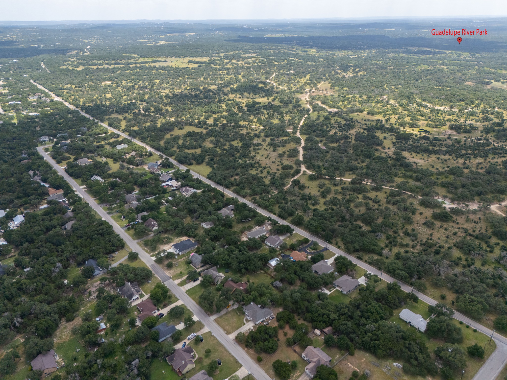 1170 Misty Lane Spring Branch, TX 78070 - Photo 4 of 24 An aerial perspective reveals a vibrant neighborhood nestled among green expanses, leading to distant natural parklands.