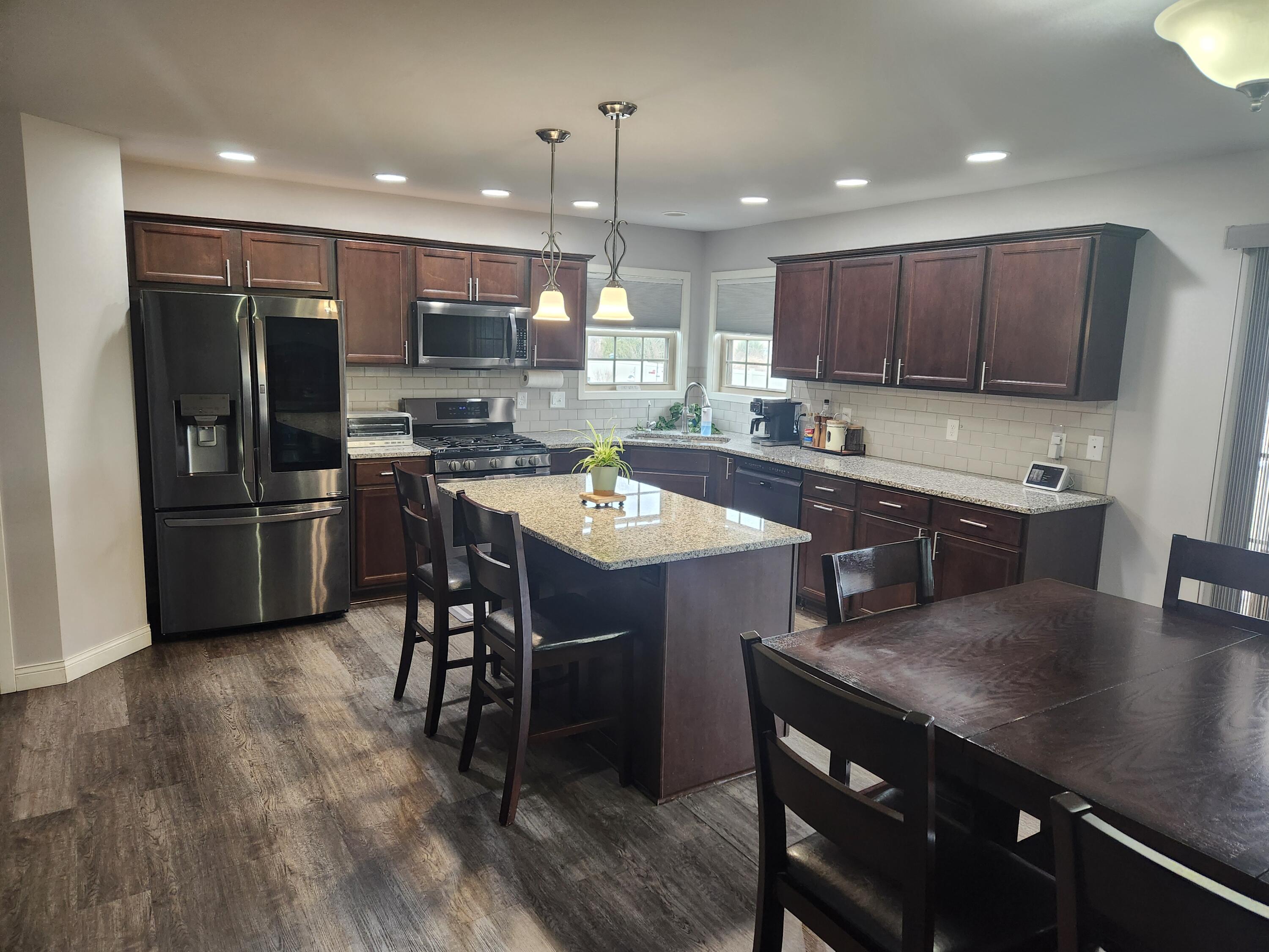 702 19th Street Southeast De Motte, IN 46310 - Photo 6 of 22 a kitchen with a table chairs refrigerator and cabinets