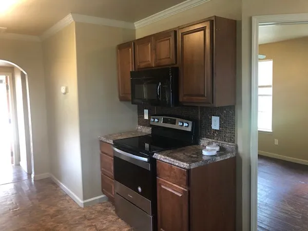 a kitchen with granite countertop a stove and a microwave