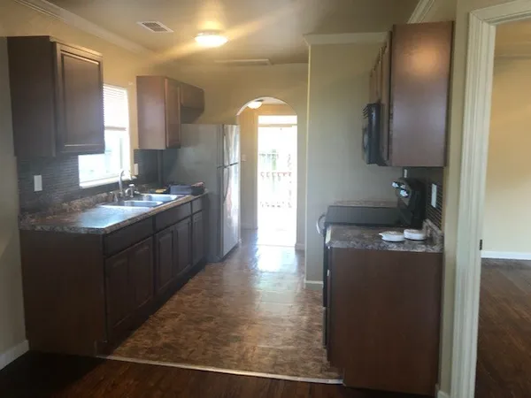 a kitchen with stainless steel appliances granite countertop a sink a stove and a refrigerator