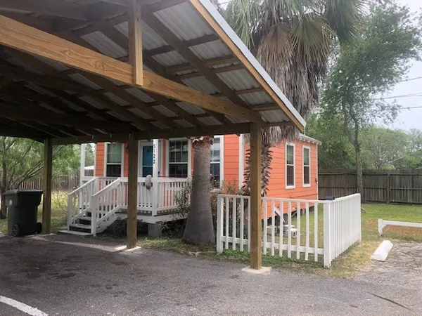 a view of a house with wooden fence and a porch