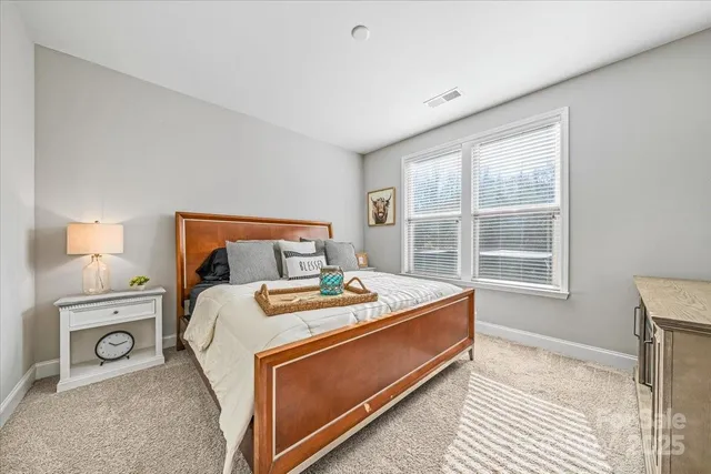 a bed sitting in a bedroom next to a window