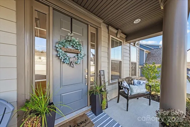 a glass door with couch and potted plants