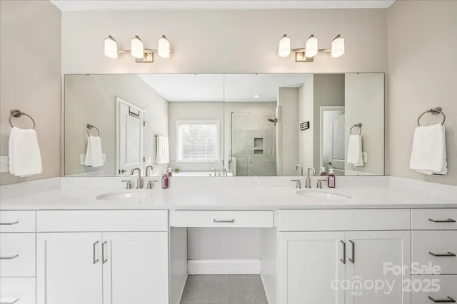 a bedroom with a bed next to a window and a chandelier