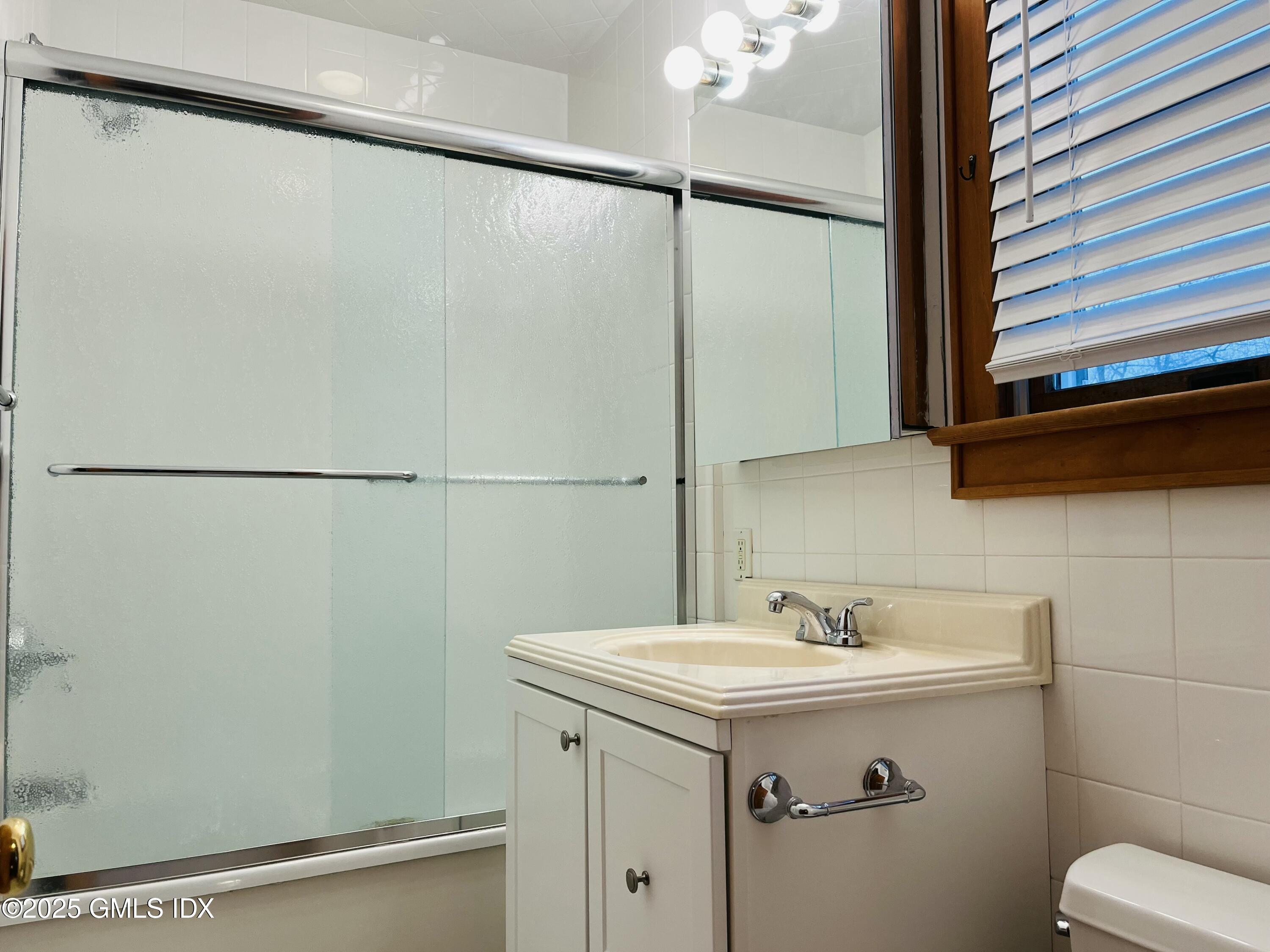 18 Grand Street, Unit 2 Greenwich, CT 06830 - Photo 9 of 10 a bathroom with a sink and mirror