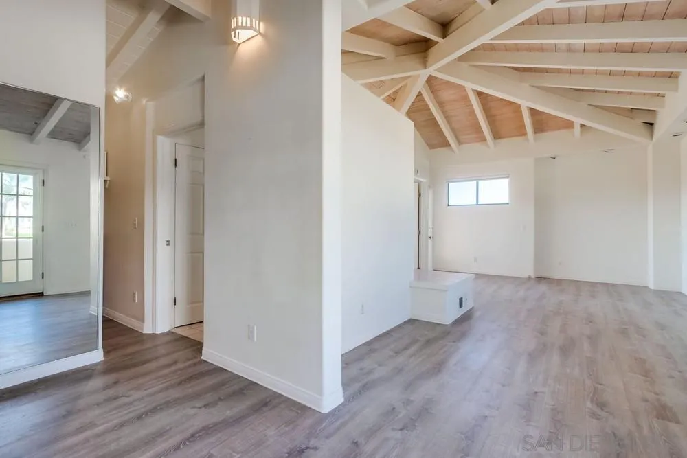 1145 La Jolla Rancho Road La Jolla, CA 92037 - Photo 19 of 45 an empty room with wooden floor and windows