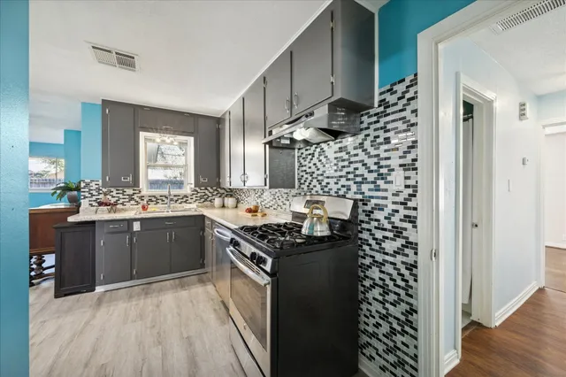 a kitchen with stainless steel appliances granite countertop a stove a sink and a refrigerator