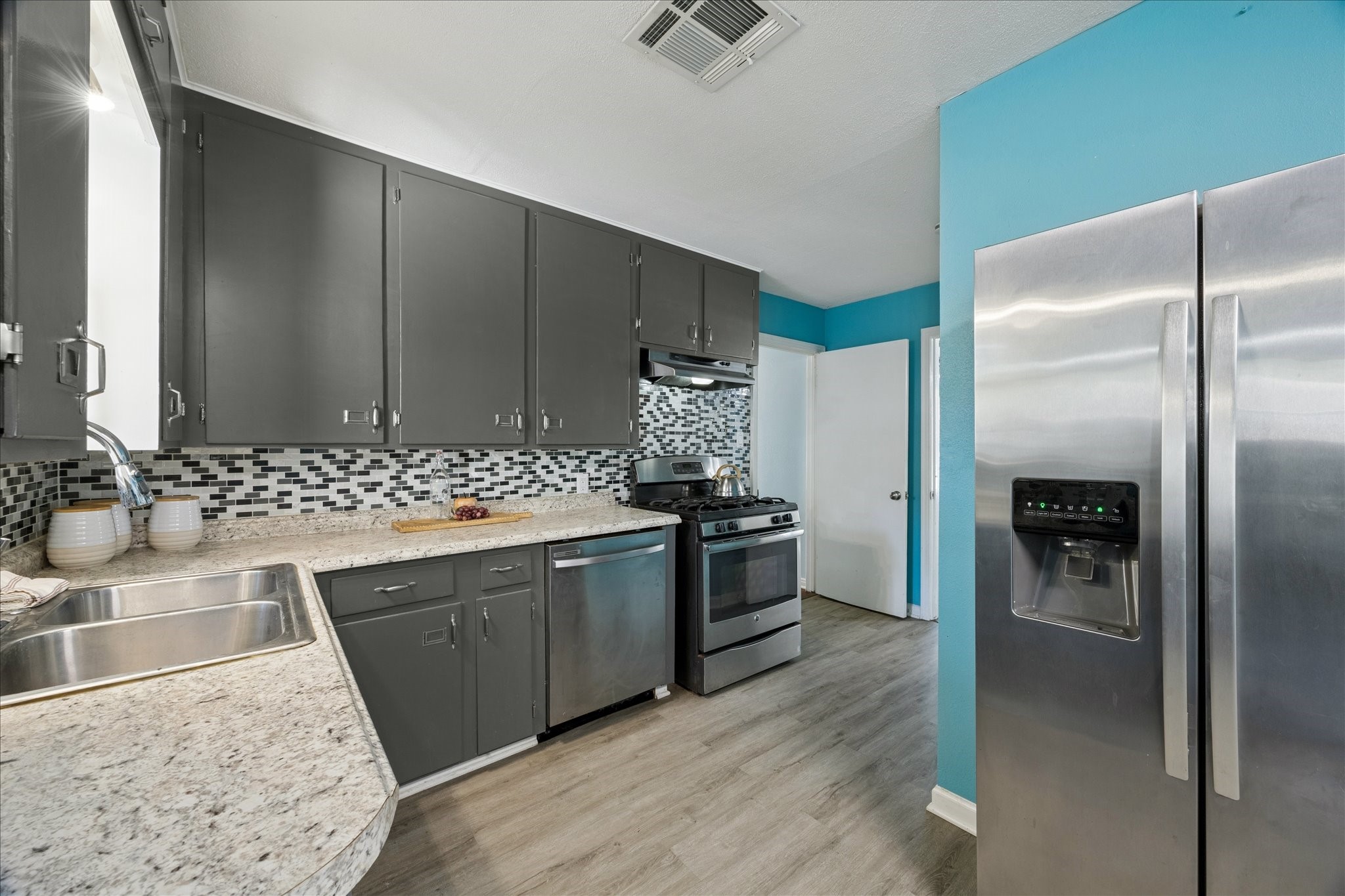 329 Robin Street Deer Park, TX 77536 - Photo 14 of 30 a kitchen with granite countertop a refrigerator and a sink