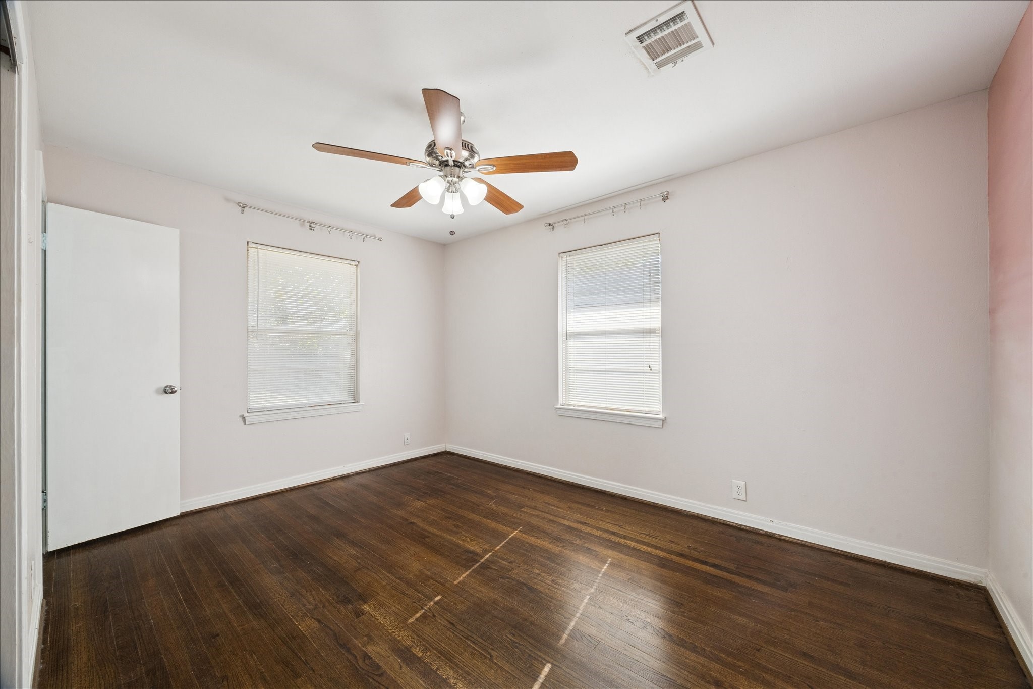 329 Robin Street Deer Park, TX 77536 - Photo 22 of 30 an empty room with wooden floor ceiling fan and windows