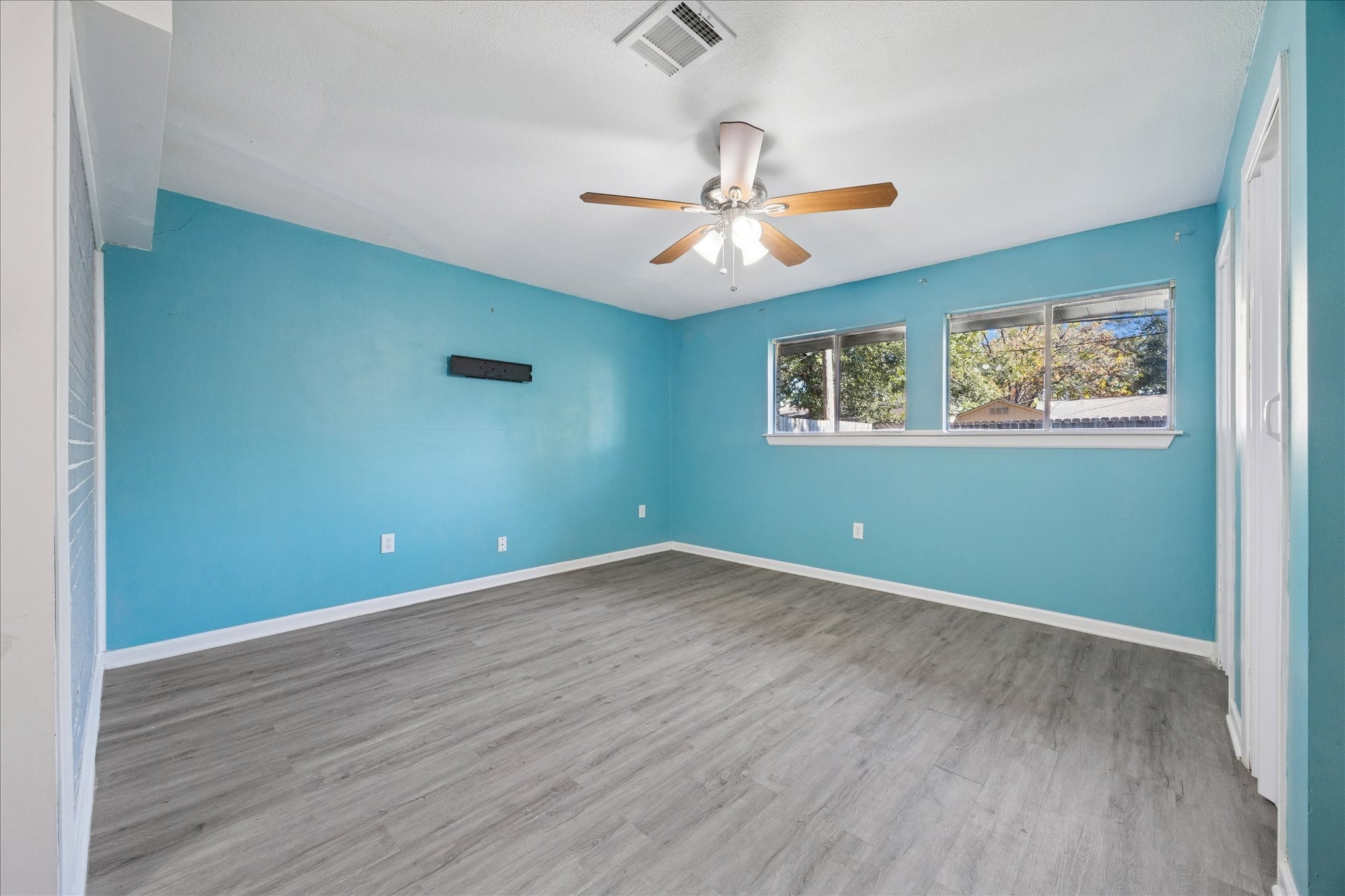 329 Robin Street Deer Park, TX 77536 - Photo 10 of 30 an empty room with wooden floor chandelier fan and windows