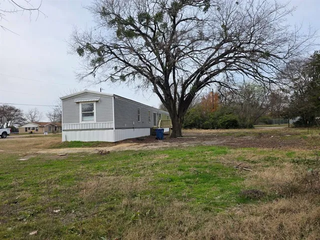 a view of backyard of house with green space