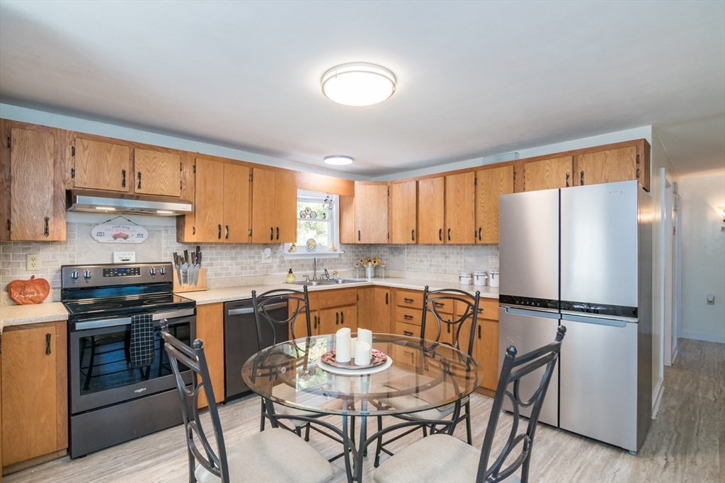 82 Comins Pond Road Warren, MA 01083 - Photo 6 of 18 a kitchen with a refrigerator a stove a sink and white cabinets with wooden floor