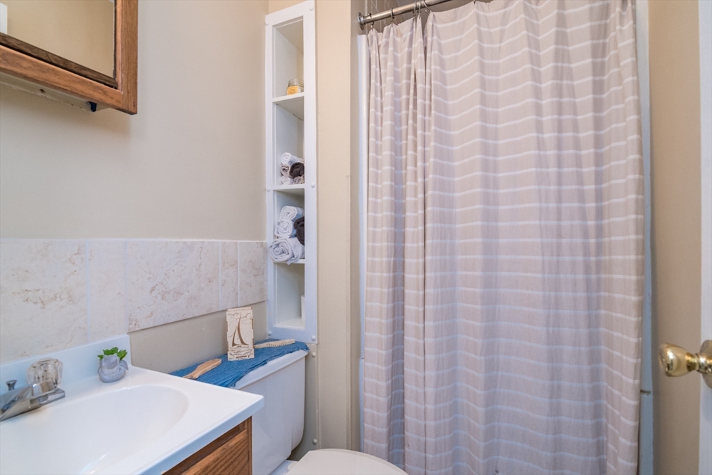 82 Comins Pond Road Warren, MA 01083 - Photo 10 of 18 a bathroom with a sink a toilet and shower curtain