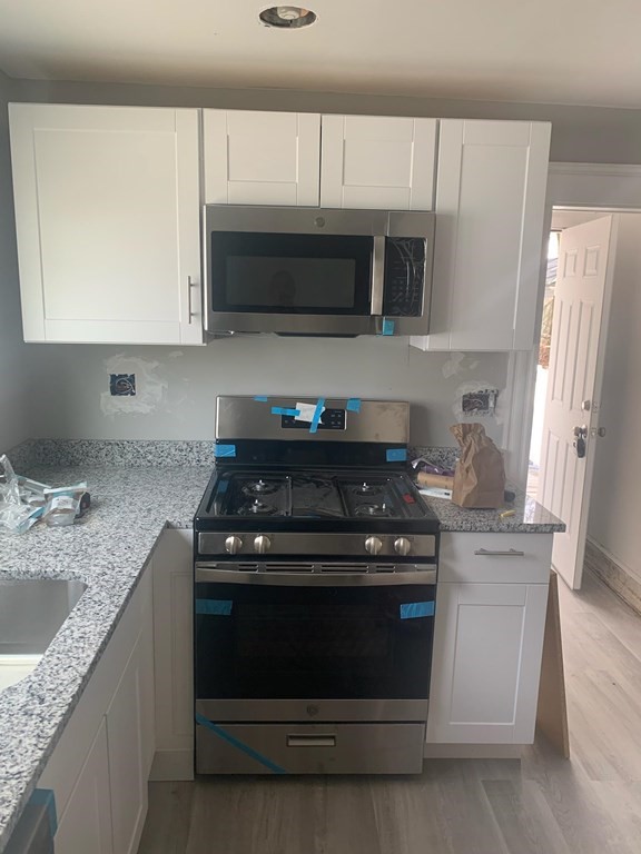 999 Rodman Street Fall River, MA 02721 - Photo 1 of 4 a kitchen with stainless steel appliances granite countertop a stove microwave and sink