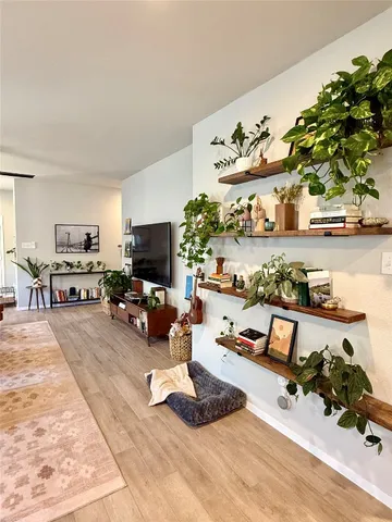 a living room with furniture a flat screen tv and a table