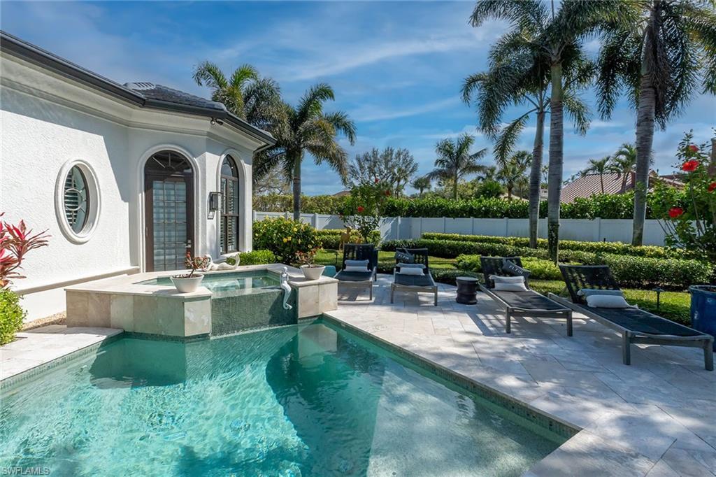 709 Teal Court Naples, FL 34108 - Photo 27 of 39 a view of a swimming pool with a table and chairs in patio