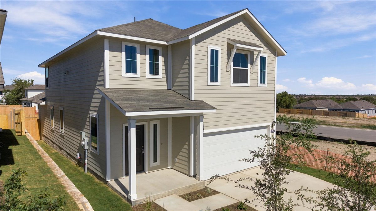 A classic two-story exterior showcases a covered front entryway alongside a concrete driveway.
